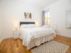 a white bedroom with a large bed and a window at Pass the Keys The White Room at Tavmar Apartments in Lincoln
