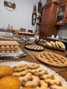 una mesa con panes, pastas y otros productos de panadería en B&B La Baita "monolocale ad uso esclusivo", en Fonni