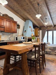 eine Küche mit einem Holztisch und einigen Stühlen in der Unterkunft B&B La Baita "monolocale ad uso esclusivo" in Fonni