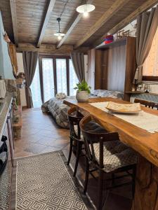 豐尼的住宿－B&B La Baita "monolocale ad uso esclusivo"，厨房配有大型木桌和椅子