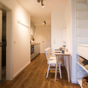 a kitchen and dining room with a table and chairs at Appartement Seerose in Poppenbüll