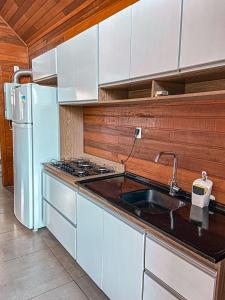 uma cozinha com um lavatório e um frigorífico branco em Vale dos Imigrantes em Bento Gonçalves