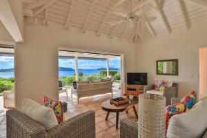 a living room with chairs and a table and a tv at Luxury Vacation Villa 2 in Pointe Milou