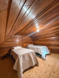 ベント・ゴンサルベスにあるVale dos Imigrantesの木造キャビン内のベッド2台が備わる部屋