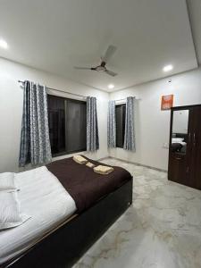 - une chambre avec un grand lit et un ventilateur de plafond dans l'établissement Tripvana Sunset Villa, à Nashik