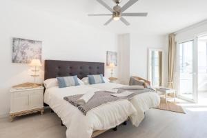 a white bedroom with a large bed and a ceiling fan at SEA VIEW & BEACH ACCESS - Center - Parking in Marbella +39 photos
