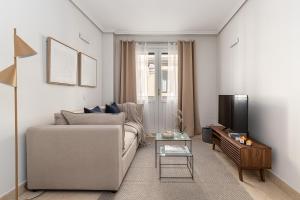 uma sala de estar com um sofá e uma televisão em BNBHolder Loving Gran Via Apartment III em Madri