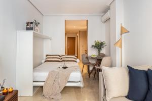 um quarto com uma cama e uma sala de jantar em BNBHolder Loving Gran Via Apartment III em Madri