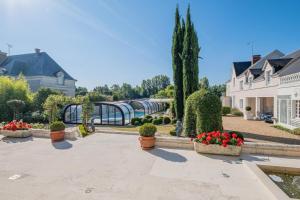 a courtyard with potted plants and a bridge at Villa Castalie - Maison de maître, grande piscine et jacuzzi, classée 5 étoiles in Montrichard