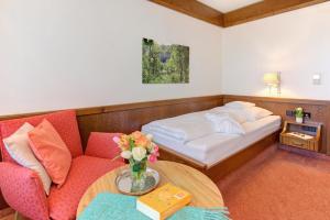 a room with a couch and a bed and a table at Hotel Restaurant Falken in Baiersbronn