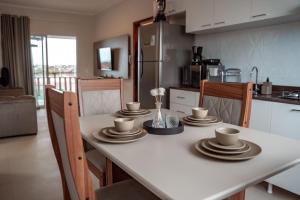 uma cozinha com uma mesa com pratos e copos em Quality - Boas Vistas em Canoa Quebrada