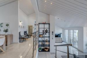 a room with white walls and a staircase with chairs at Luxury apt w shared pool 3 balconies and terrace in Omiš