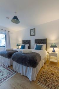 2 Betten in einem Schlafzimmer mit 2 Lampen und einem Teppich in der Unterkunft Renada Cottage in Dingle