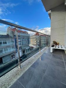 een balkon met een tafel en uitzicht op de gebouwen bij Apartamento luminoso y acogedor in Lalín