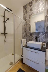y baño con ducha, lavabo y espejo. en Renada Cottage en Dingle
