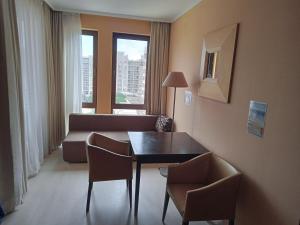 サニービーチにあるArendo Sun - studio in Barceló Hotelのソファとテーブルと椅子のあるリビングルーム