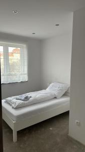 Cama blanca en habitación con ventana en Apartament 33 Park City en Ostrów Wielkopolski