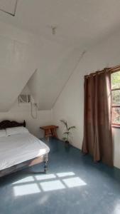 a bedroom with a bed and a window at KALAYAAN INN in Port Barton