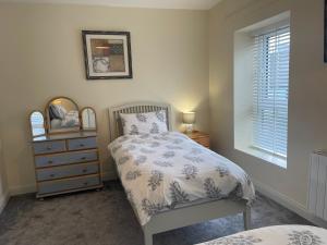 1 dormitorio con cama, tocador y espejo en Dublin Road Townhouse, en Carrick on Shannon