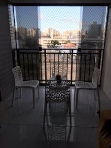 2 Stühle und ein Tisch auf einem Balkon mit Aussicht in der Unterkunft Quarto no Dubai Residence in São Luís