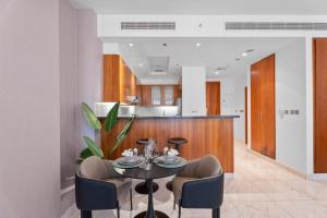 Nasma Luxury Stays - Modern Studio Apartment with City View In DIFC في دبي: غرفة طعام مع طاولة وكراسي