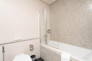 a bathroom with a shower and a toilet at Nasma Luxury Stays - Modern Studio Apartment with City View In DIFC in Dubai