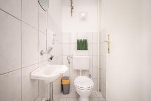 biała łazienka z toaletą i umywalką w obiekcie Whitefield Apartment w Budapeszcie
