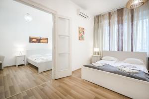 sypialnia z 2 łóżkami i dużym lustrem w obiekcie Whitefield Apartment w Budapeszcie