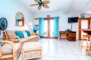 sala de estar con sofá y TV en Condo 26 at Caribe Island Gold Standard Certified, en San Pedro