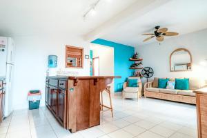 cocina y sala de estar con paredes azules y sofá en Condo 26 at Caribe Island Gold Standard Certified, en San Pedro