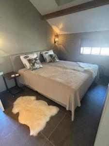 1 dormitorio con 1 cama grande con alfombra en Bed & Breakfast+ De Kooimolen, en Dreumel