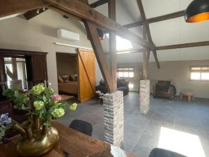 a living room with a vase of flowers on a table at Bed & Breakfast+ De Kooimolen in Dreumel