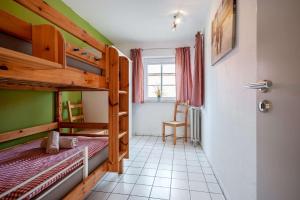 Cette chambre comprend 2 lits superposés et une porte. dans l'établissement Ferienhof Gröne, à Eutin