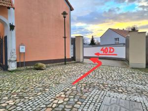 uma seta vermelha apontando para uma porta de um edifício em Ferienhaus em Barleben