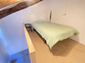 Un pequeño dormitorio con una cama verde en una habitación en Cardeñosa habitaciones, en Madrid