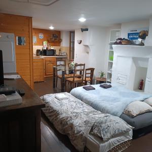 two beds in a room with a desk and a kitchen at l'HYPERCENTRE in Clermont-Ferrand
