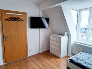 Zimmer mit einer Tür und einem TV an der Wand in der Unterkunft Work & Stay in Wismar in Wismar