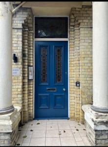 eine blaue Tür in einem Backsteingebäude mit einem Fenster in der Unterkunft Norton house in Brighton & Hove