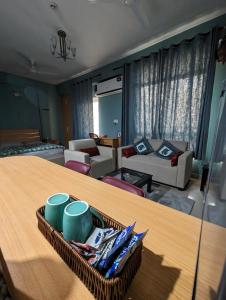 Habitación con mesa y sala de estar. en Aqua Inn - Studio Apartment, en Greater Noida