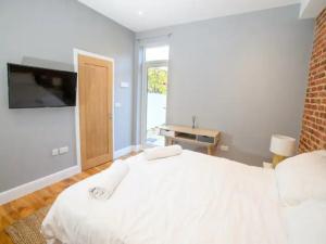 a bedroom with a white bed and a television at Pass the Keys Garden Room in City Centre in Lincoln