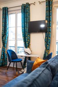 - un salon avec un canapé bleu et une chaise dans l'établissement Le "Boudoir" Appartement de Charme climatisé en Plein Centre, à Bourges