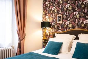 - une chambre avec un lit et un papier peint floral dans l'établissement Le "Boudoir" Appartement de Charme climatisé en Plein Centre, à Bourges