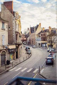 une rue de la ville avec des voitures garées sur la route dans l'établissement Le "Boudoir" Appartement de Charme climatisé en Plein Centre, à Bourges