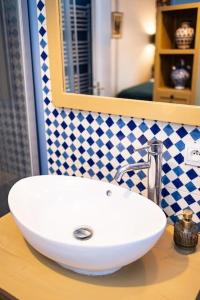 - un lavabo blanc sur un comptoir dans la salle de bains dans l'établissement Le "Boudoir" Appartement de Charme climatisé en Plein Centre, à Bourges