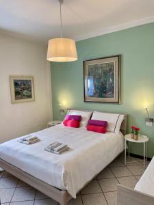 ドルメッレットにあるBnbook Lago Maggiore Studio 2のベッドルーム(ピンクの枕が付く大きな白いベッド付)