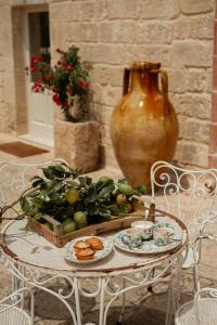 una mesa con un bol de fruta y un jarrón en Masseria del Gigante en Carpignano Salentino