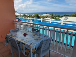 a table on a balcony with a view of the ocean at Villa Oceane in Le Moule