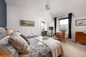 Strathardle Lodge في Kirkmichael: غرفة نوم بسرير وطاولة وكرسي