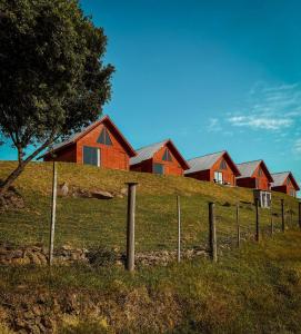 uma fila de casas numa colina com uma cerca em Vale dos Imigrantes em Bento Gonçalves