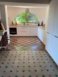 a kitchen with a checkered floor and a window at Mas provençal dans un vignoble in La Motte